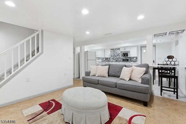 living room featuring recessed lighting, visible vents, and stairway