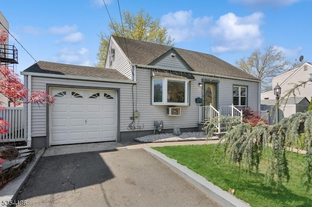 view of front of house with a garage, a shingled roof, and aphalt driveway