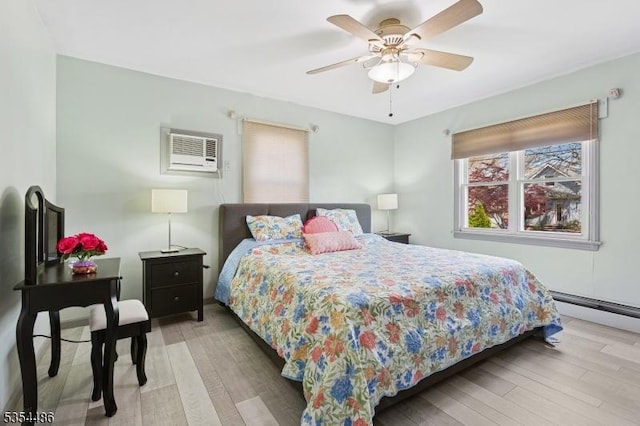bedroom featuring multiple windows, light wood-style flooring, and a wall mounted air conditioner