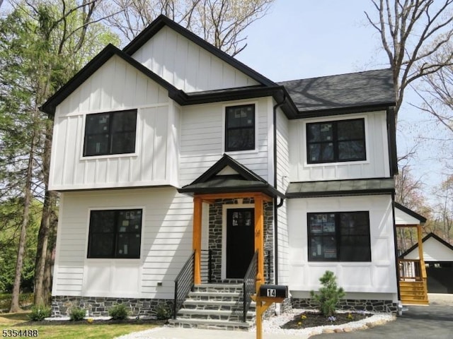 modern farmhouse featuring board and batten siding, roof with shingles, and entry steps