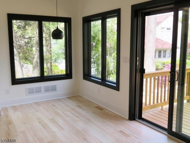 spare room with visible vents, baseboards, and wood finished floors