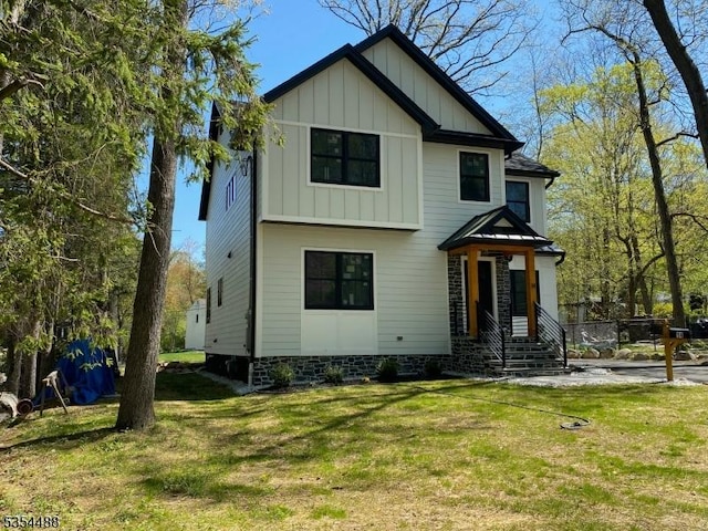 view of front facade with board and batten siding and a front lawn