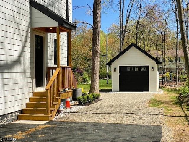 detached garage with central air condition unit and driveway