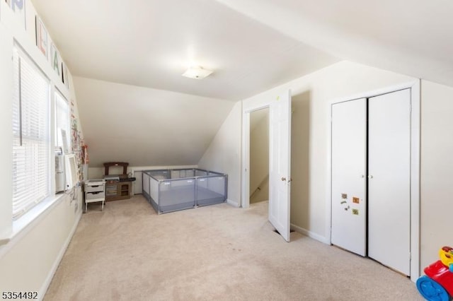 bonus room with baseboards, light carpet, and lofted ceiling