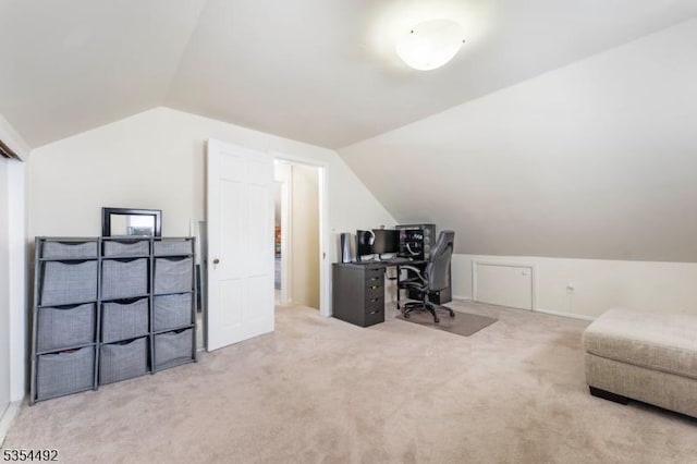 carpeted home office featuring lofted ceiling
