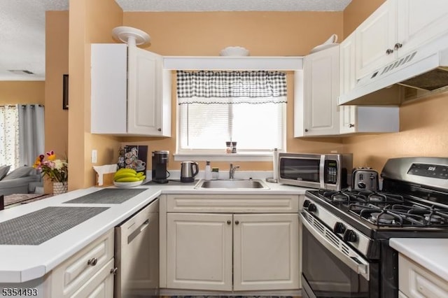 kitchen featuring a sink, light countertops, stainless steel appliances, and white cabinetry