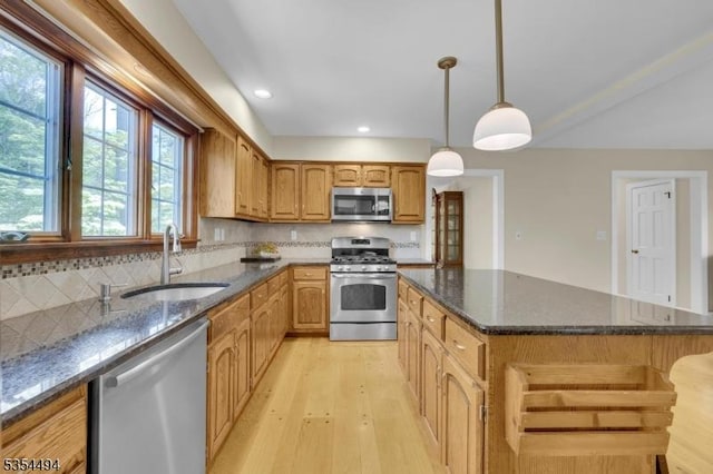 21 Dorset Rd, Washington Twp, NJ 07853 - kitchen with stainless steel appliances, a sink, light wood finished floors, a center island, and dark stone countertops