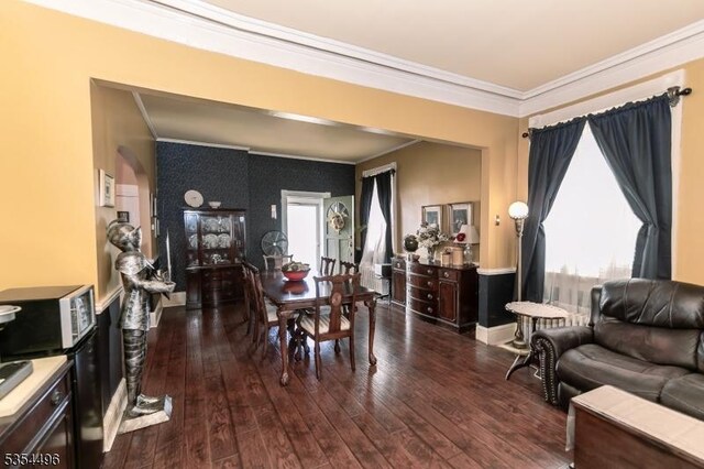 dining area with crown molding, plenty of natural light, and hardwood / wood-style flooring