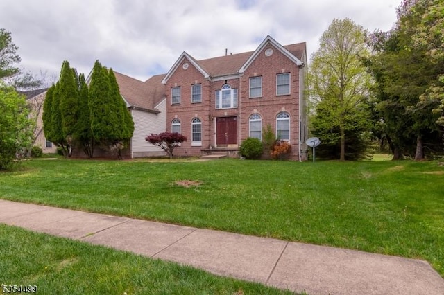 view of front of home featuring brick siding and a front lawn