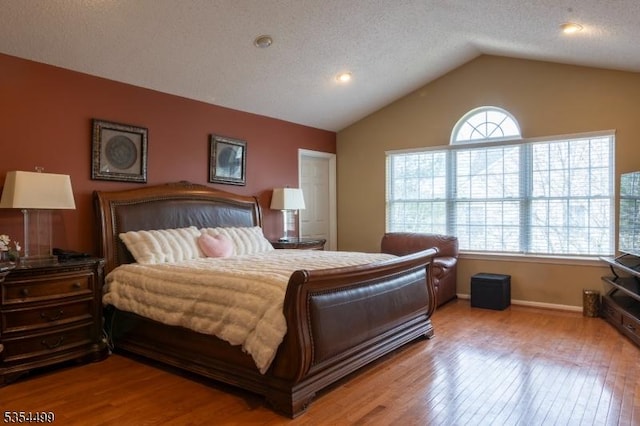bedroom featuring baseboards, vaulted ceiling, and wood finished floors