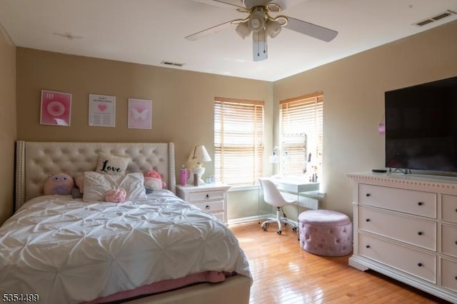 bedroom featuring ceiling fan, visible vents, baseboards, and light wood finished floors