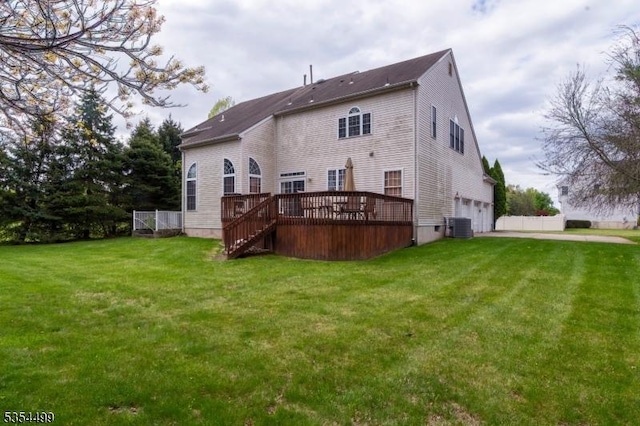 back of house with stairway, a deck, a lawn, and a garage