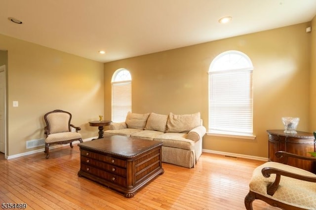living room featuring recessed lighting, baseboards, visible vents, and light wood-type flooring