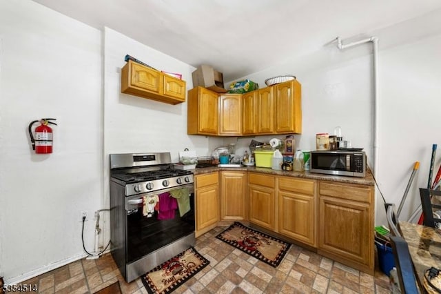 kitchen with appliances with stainless steel finishes and brick patterned floor