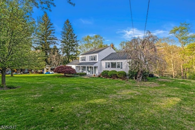 traditional-style house with a chimney and a front yard