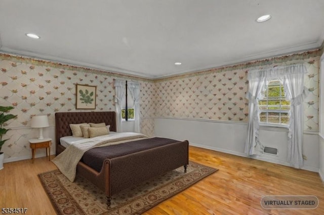 bedroom with crown molding, wallpapered walls, and baseboards