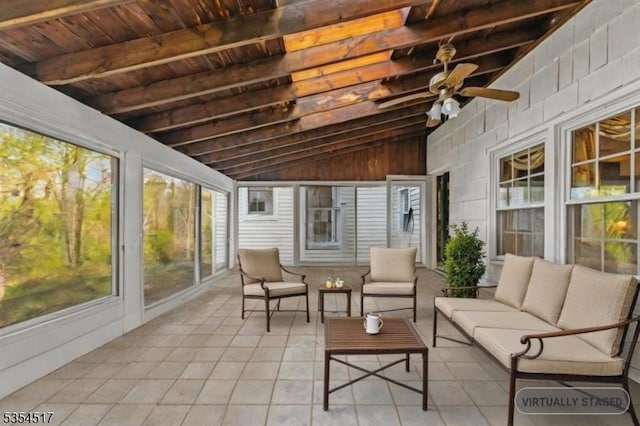 sunroom / solarium featuring beamed ceiling, ceiling fan, an outdoor living space, and a wealth of natural light