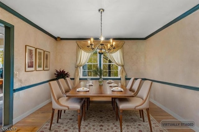 dining space with an inviting chandelier, baseboards, crown molding, and wood finished floors