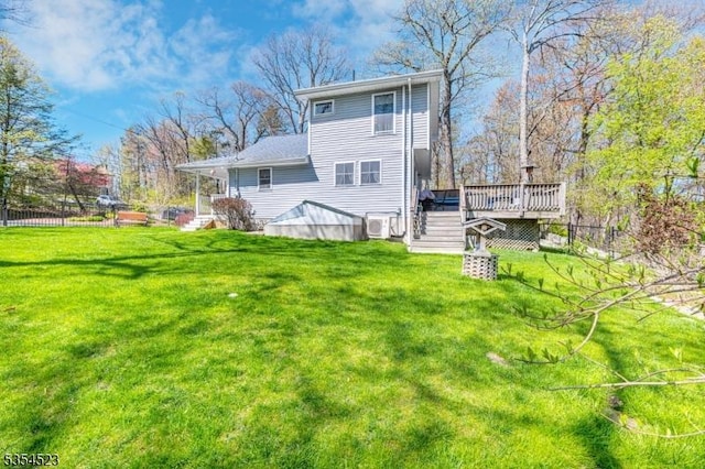 back of house featuring a lawn, stairway, fence, and a deck