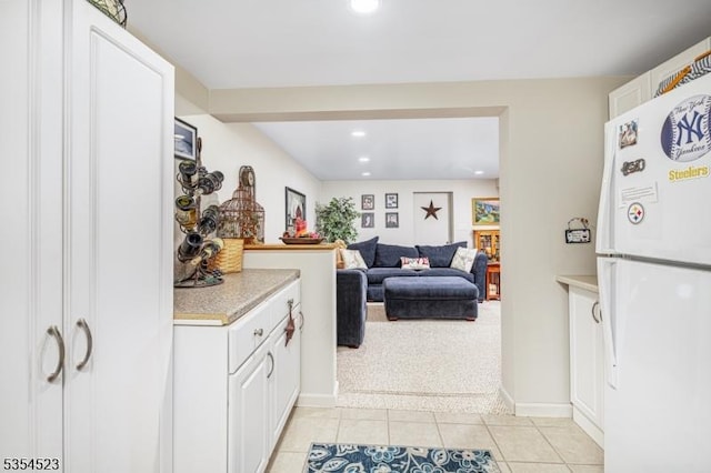 kitchen featuring light countertops, light tile patterned floors, white cabinets, freestanding refrigerator, and recessed lighting