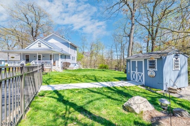 view of yard featuring a porch, an outdoor structure, and a storage unit