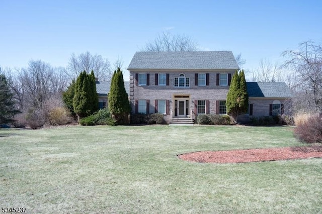 colonial-style house featuring a front yard