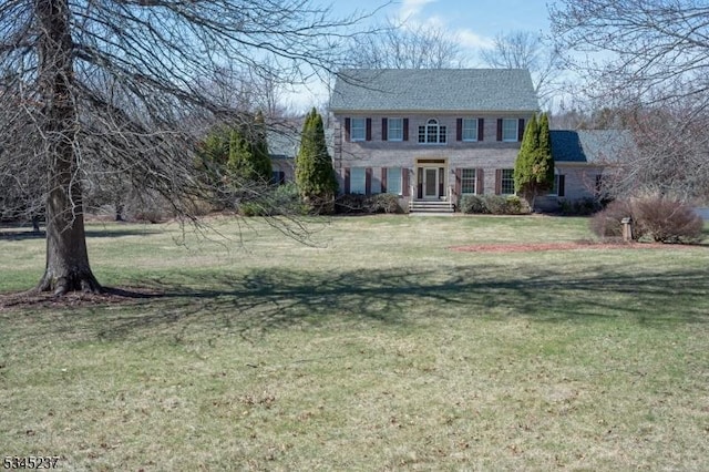 colonial inspired home featuring a front lawn