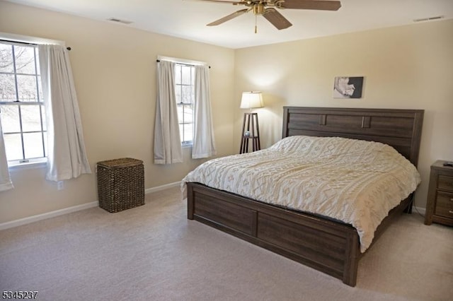bedroom featuring baseboards, light colored carpet, and visible vents