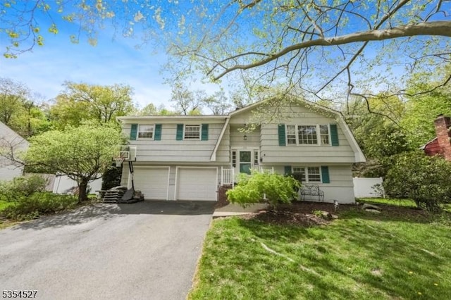bi-level home with a garage, driveway, and a front yard