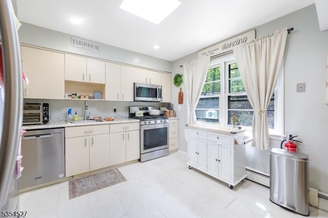 kitchen with a toaster, baseboard heating, light countertops, a sink, and stainless steel appliances