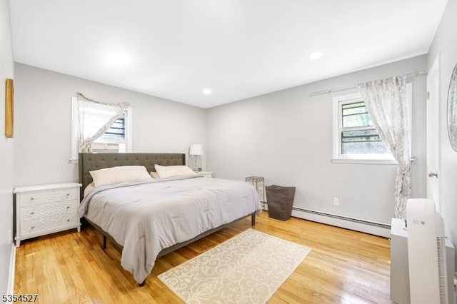 bedroom featuring recessed lighting, wood finished floors, and baseboard heating