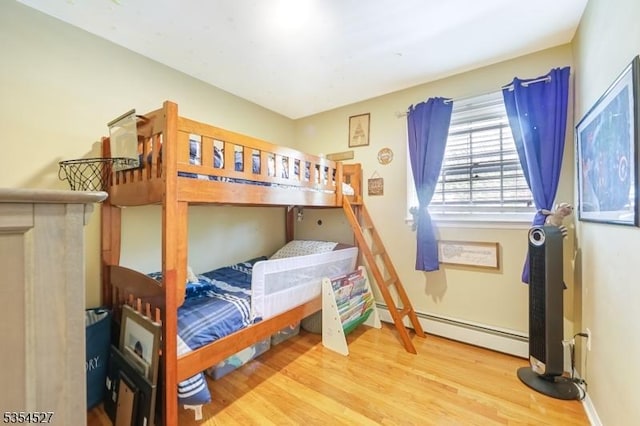 bedroom featuring wood finished floors and baseboard heating