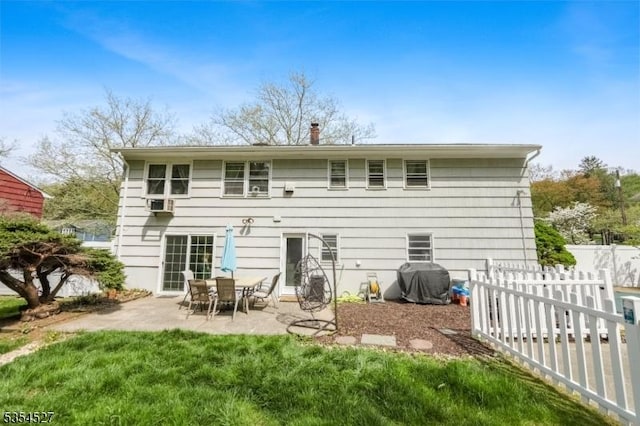 back of property featuring a lawn, a patio, and fence