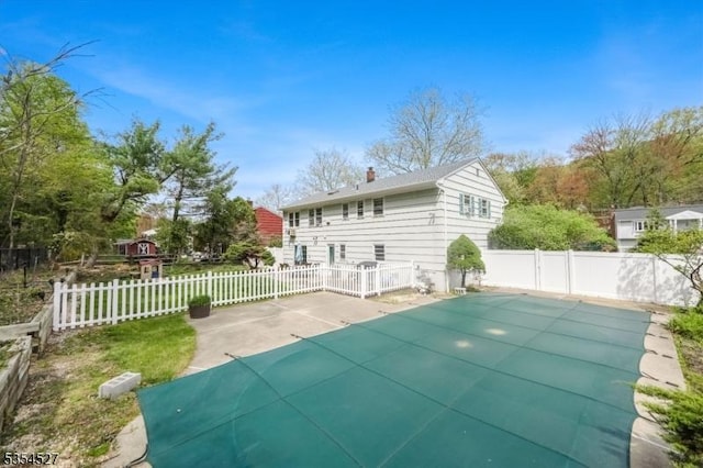 rear view of property featuring a patio, fence, and a chimney