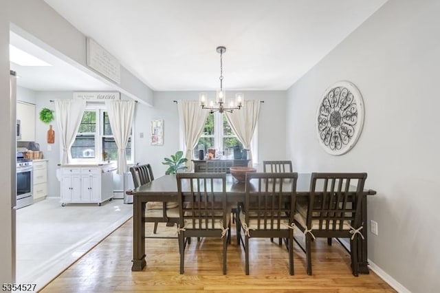 dining area featuring an inviting chandelier, light wood-style flooring, and plenty of natural light