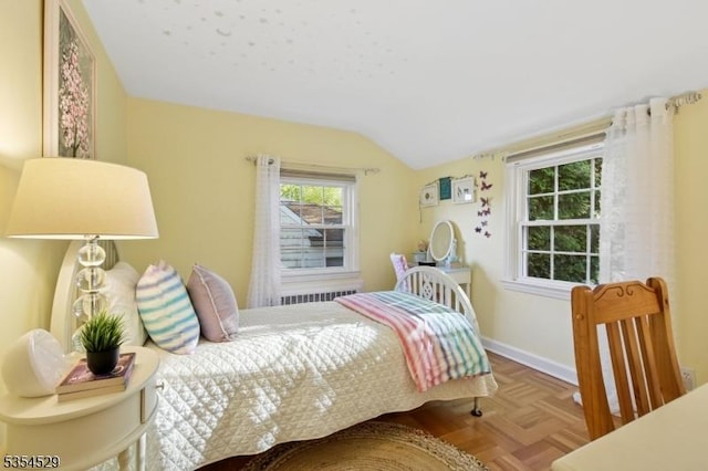 bedroom with radiator heating unit, baseboards, and lofted ceiling