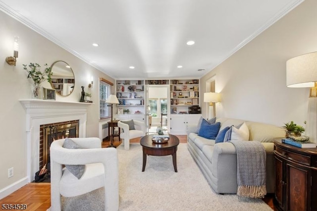 living area featuring crown molding, built in features, a glass covered fireplace, and recessed lighting
