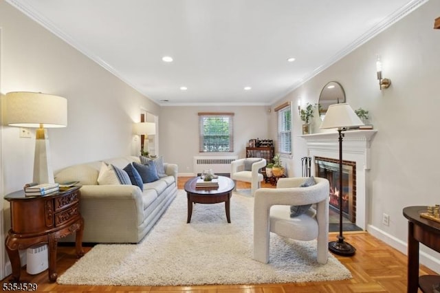 living room with ornamental molding, radiator, a glass covered fireplace, baseboards, and recessed lighting