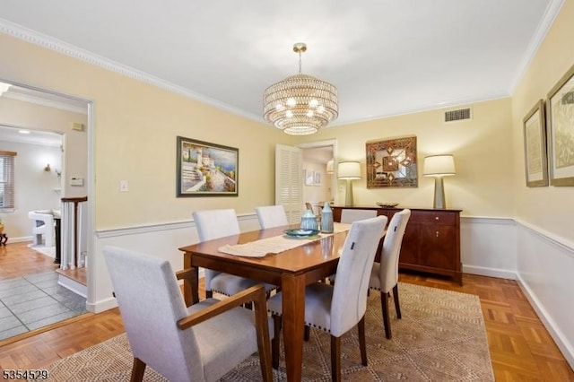 dining room with a notable chandelier, visible vents, and ornamental molding