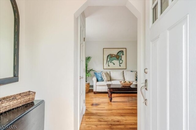 entryway with light wood-style flooring and arched walkways