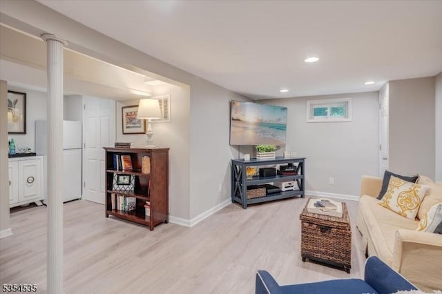 living area with light wood-style floors, baseboards, and recessed lighting