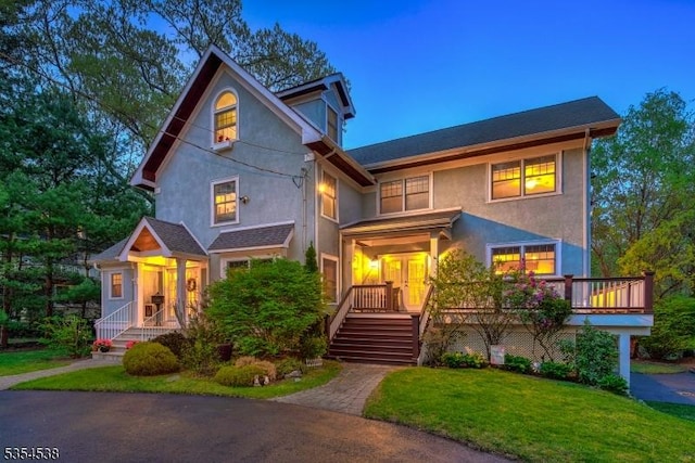 view of front facade featuring french doors, a front lawn, and stucco siding