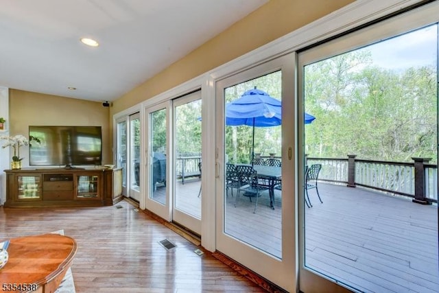 doorway to outside with recessed lighting, visible vents, plenty of natural light, and wood finished floors