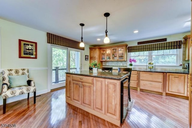 kitchen featuring glass insert cabinets, a healthy amount of sunlight, and light wood-type flooring