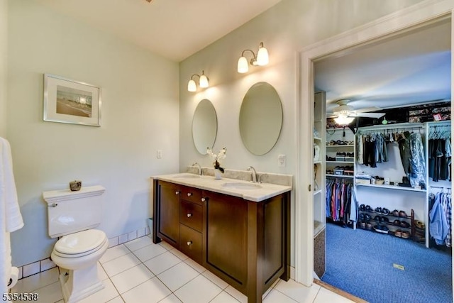 bathroom featuring double vanity, toilet, ceiling fan, and a sink