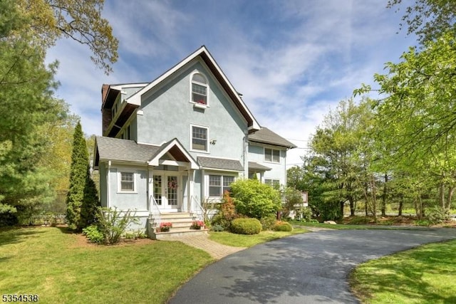 view of front of property featuring french doors, stucco siding, and a front yard