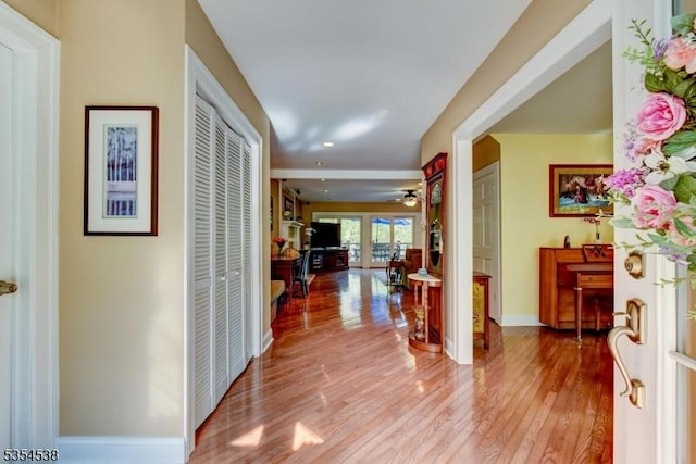 hallway with baseboards, recessed lighting, and wood finished floors