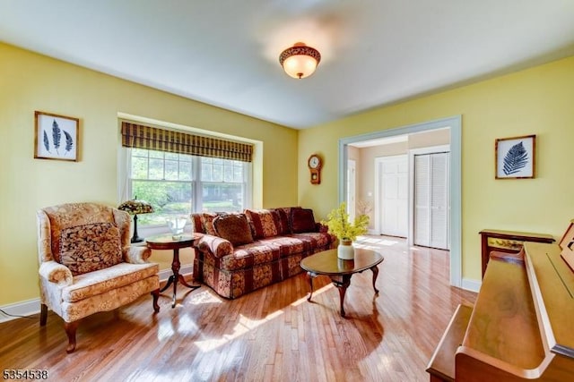 living area with baseboards and wood finished floors