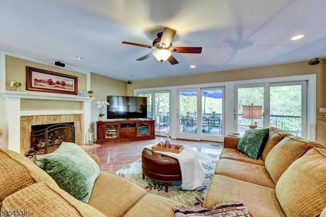 living area featuring a healthy amount of sunlight, a tiled fireplace, a ceiling fan, and recessed lighting