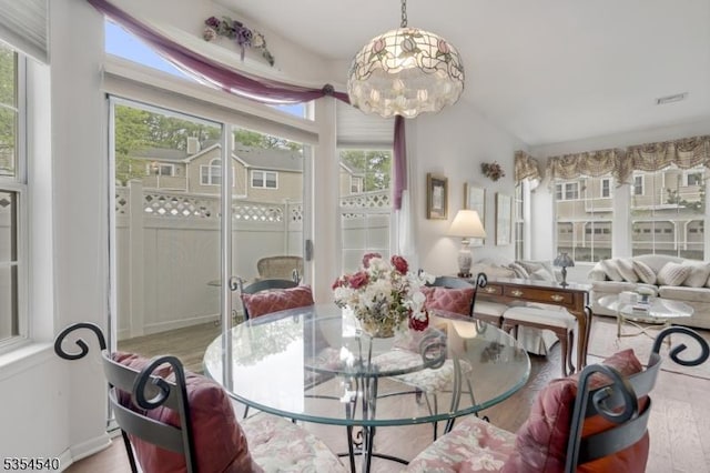 dining room with plenty of natural light, wood finished floors, and a chandelier